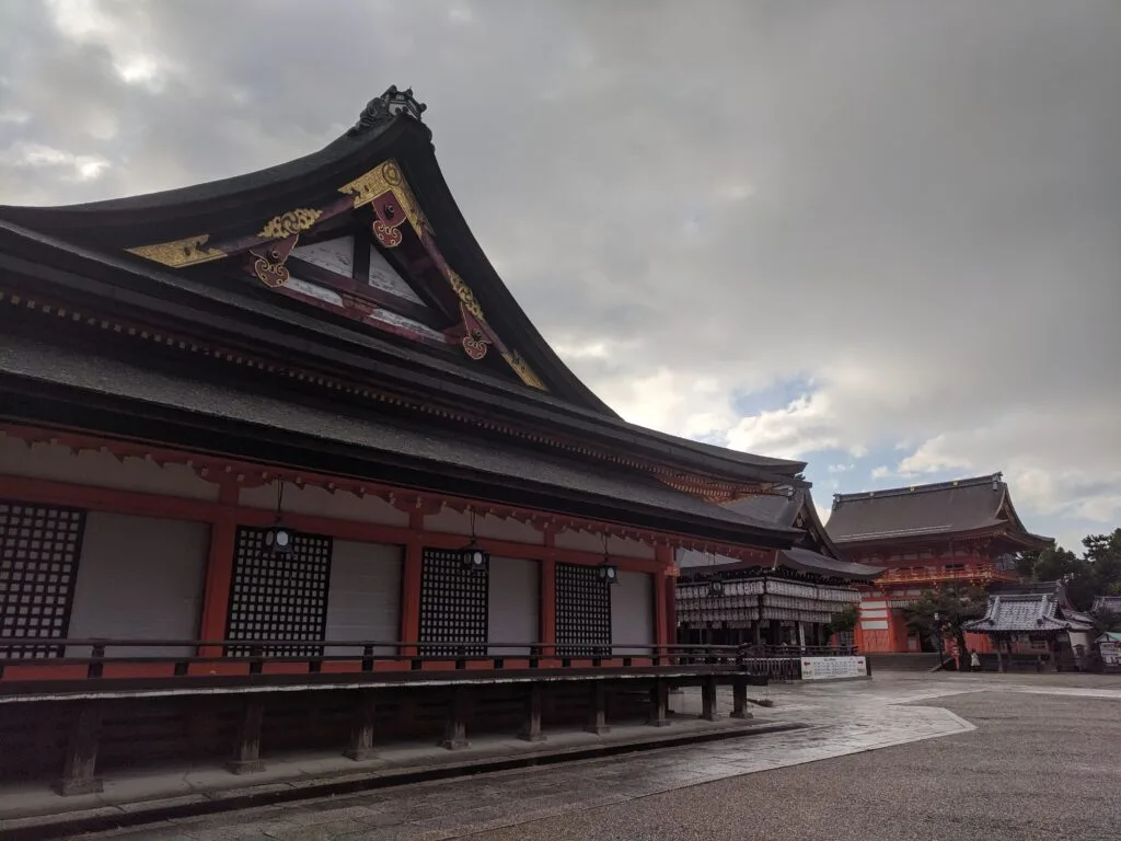 A view of traditional Japanese architecture at Fushimi Inari Taisha, featuring the intricate design of the temple roofs.