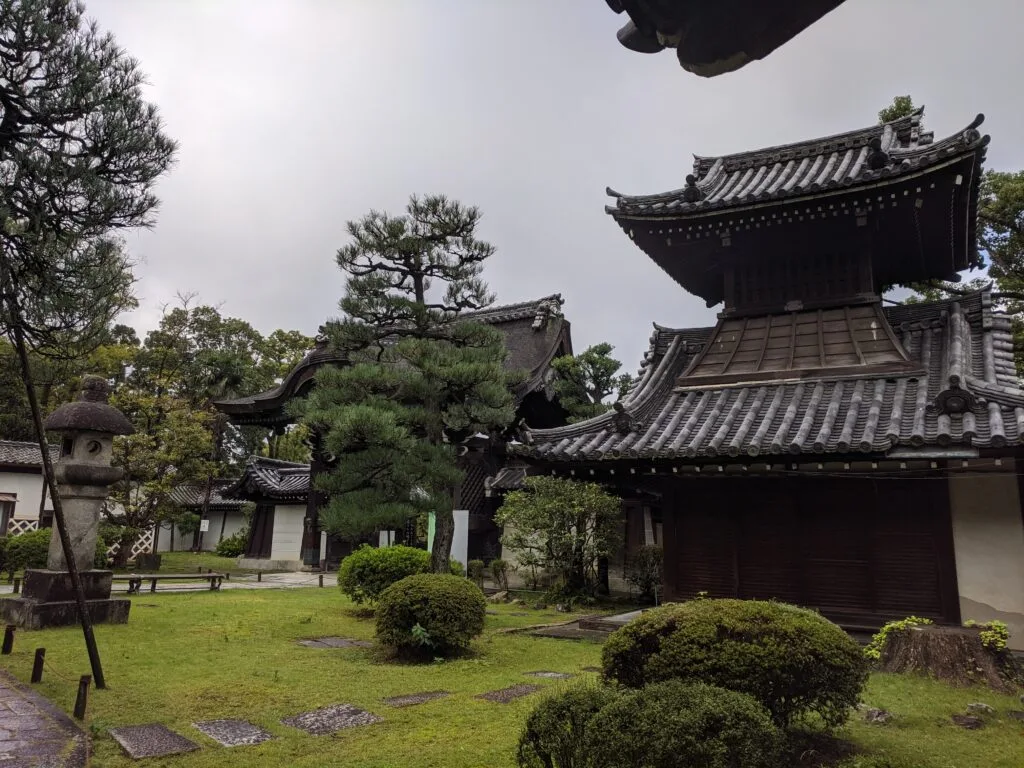 A peaceful view of the Ryoan-ji temple grounds with traditional Japanese architecture and landscaping.