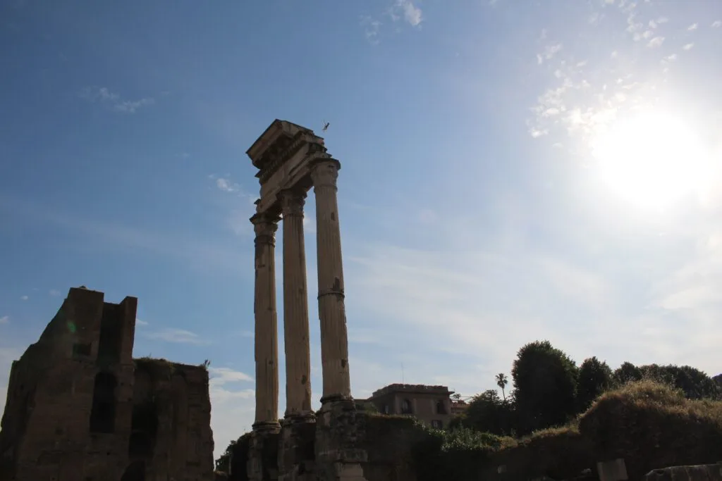 Tall, ancient columns standing against a bright blue sky.