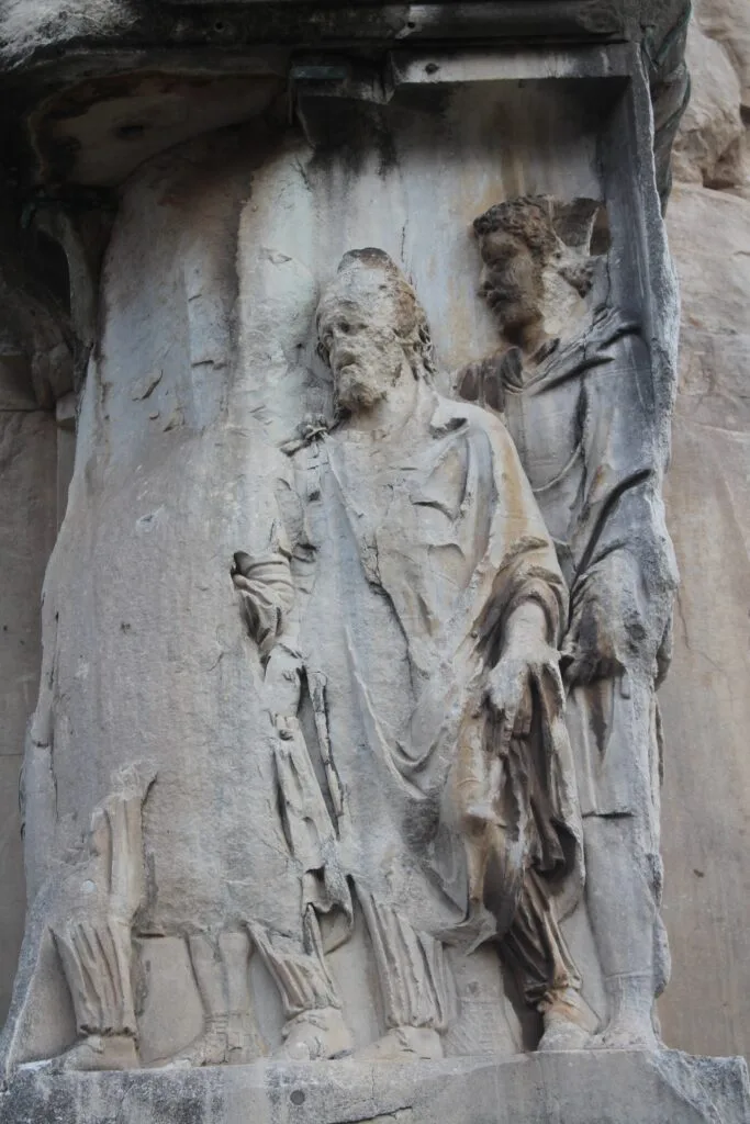A close-up of a stone carving showing figures in togas.