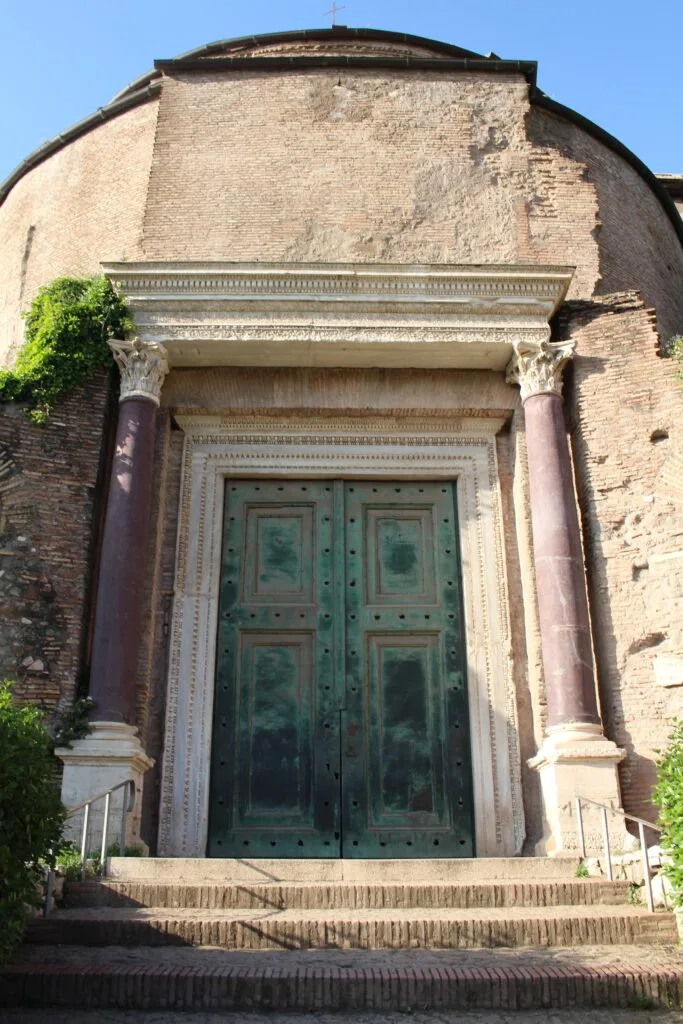 The entrance to the Temple of Romulus, featuring large bronze doors and marble columns.