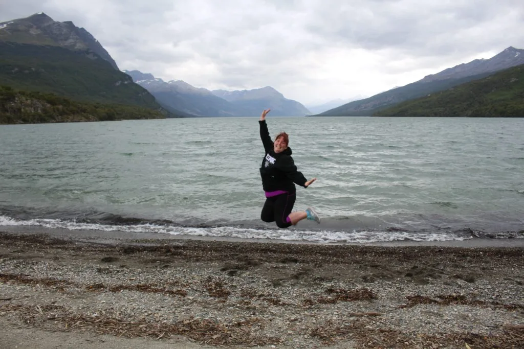 Me jumping in the National Park after our ride on the train at the end of the world. In the back are the mountains of Chile