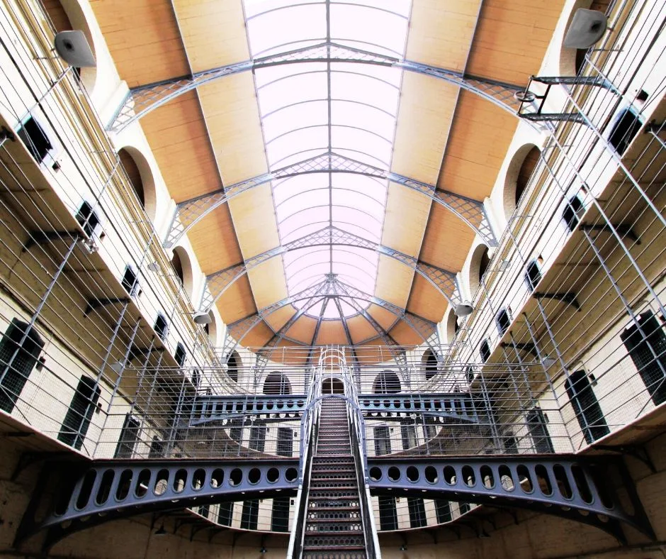 Interior view of the Kilmainham Gaol Museum ceiling, featuring intricate ironwork and a vaulted design.