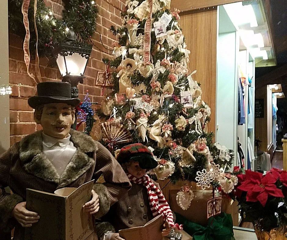 Holiday decor with two dolls singing carols. 