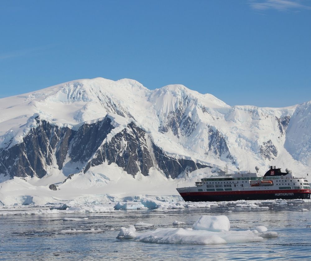 Fun Fact About Antarctica: The  mountains can be covered with hundreds of feet of ice! Cruise ship next to mountains.