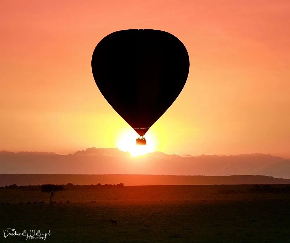 The silhouette of a hot air balloon in the rising sun over the Masai Mara
