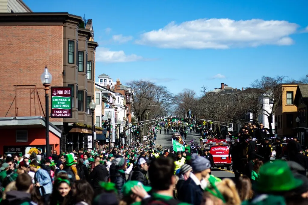 A crowded street filled with people wearing green, celebrating St. Patrick's Day in Boston.