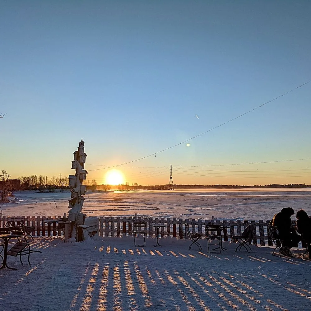 Restaurant with outdoor seating next to a frozen lake in Finland