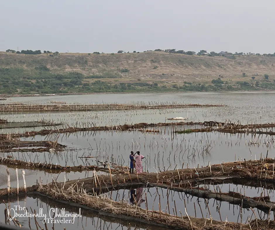 Two women standing near the salt mines in Lake Katwe.